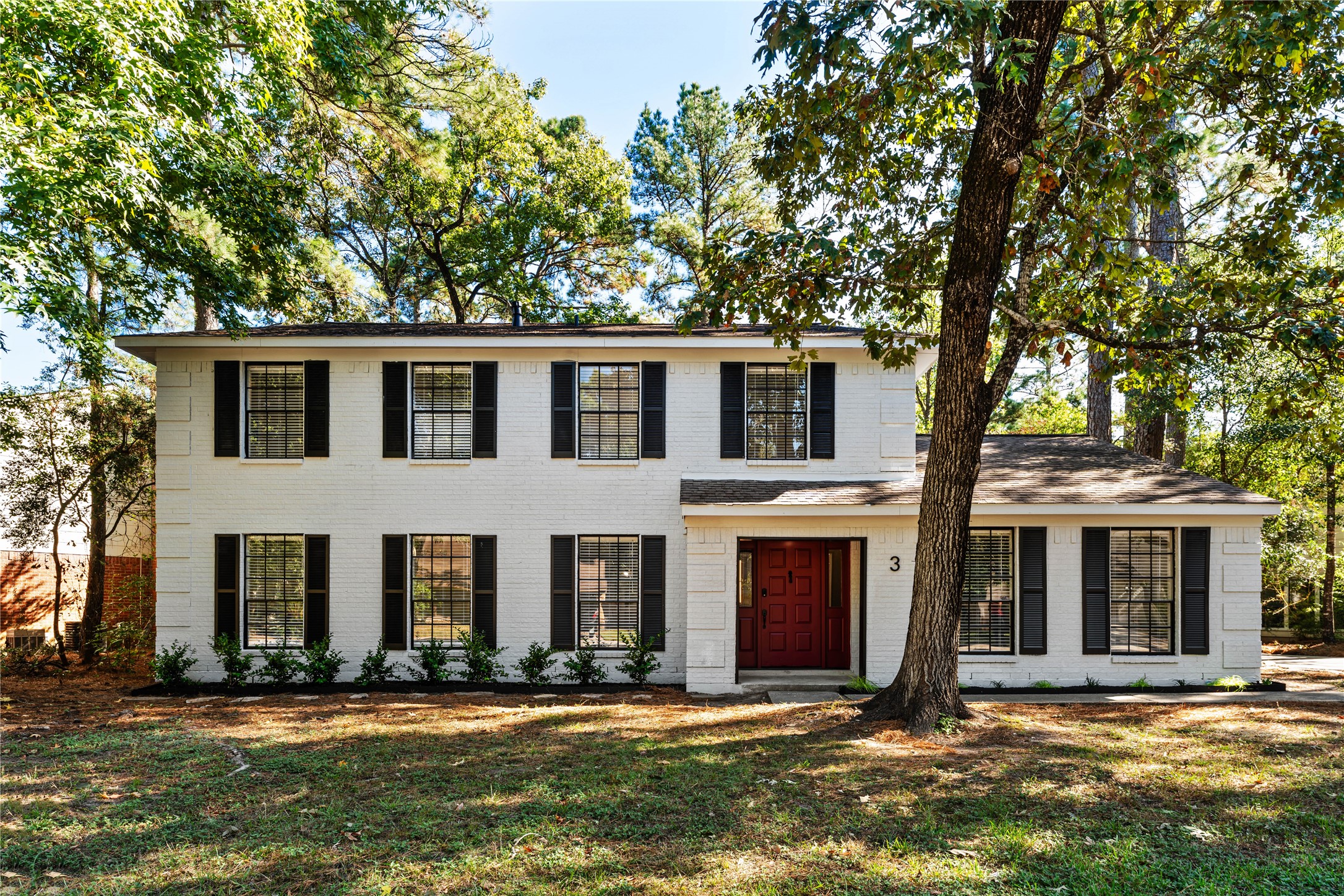 a front view of a house with yard and trees
