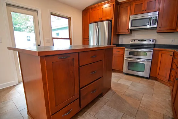 a kitchen with stainless steel appliances granite countertop a refrigerator a sink dishwasher and a stove