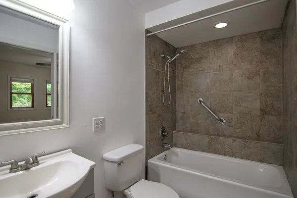 an empty room with wooden floor chandelier fan and windows