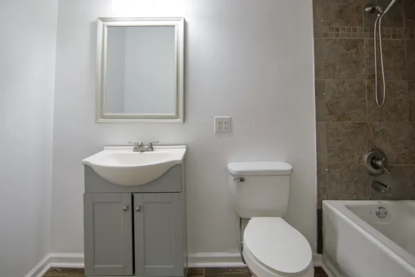an empty room with wooden floor closet and windows