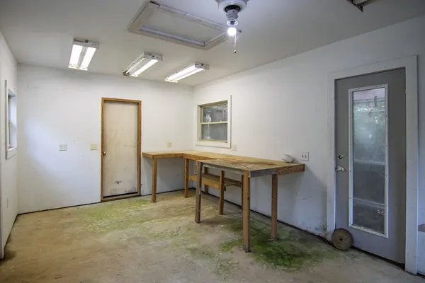 a view of backyard of house with wooden fence and large trees