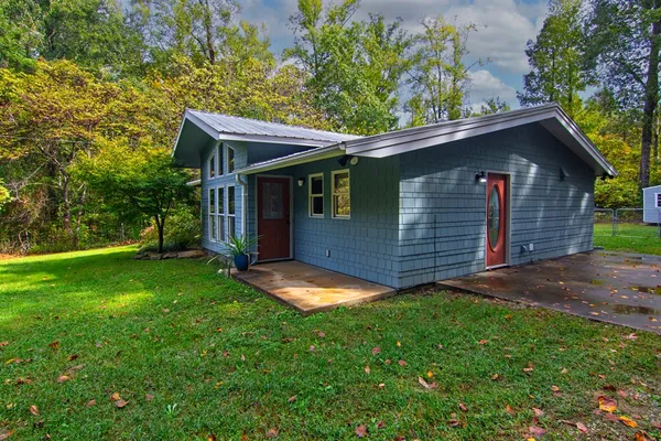 a view of backyard of house with green space