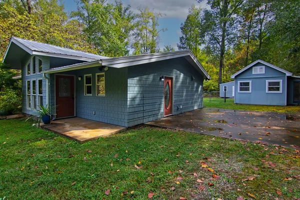 a view of a house with a backyard and deck