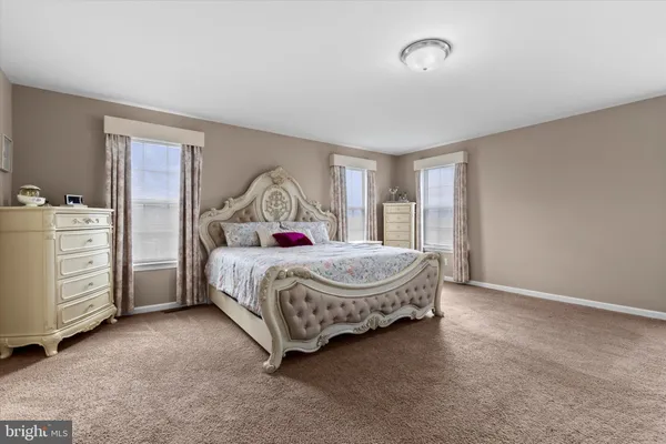 a spacious bedroom with a bed and cabinet