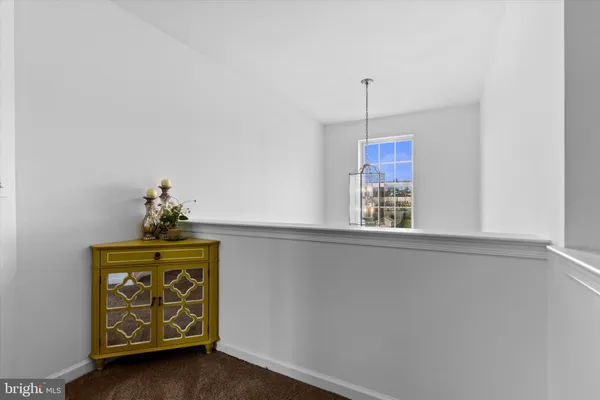 a living room with a flat screen tv on dresser and a wooden floor