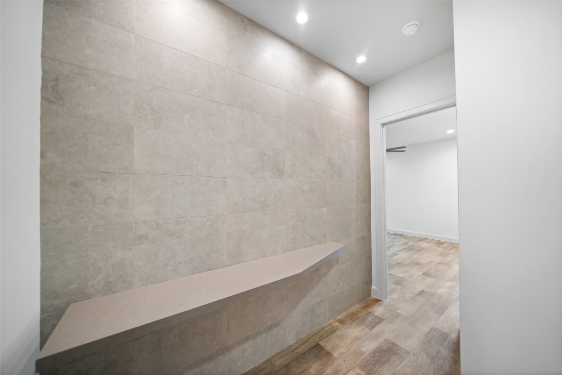 6809 Troya Lane Houston, TX 77092 - Photo 19 of 49 A beautifully tiled accent wall adds texture and warmth to the hallway leading into the primary suite, an elevated design detail that sets this home apart.