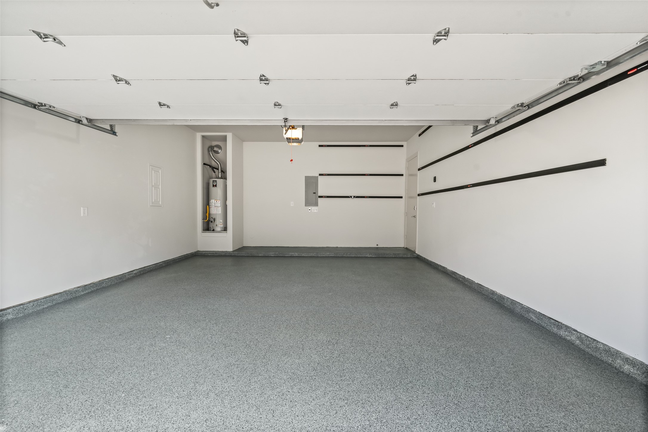 6809 Troya Lane Houston, TX 77092 - Photo 40 of 49 Freshly painted garage with durable epoxy floors and built-in wall storage.