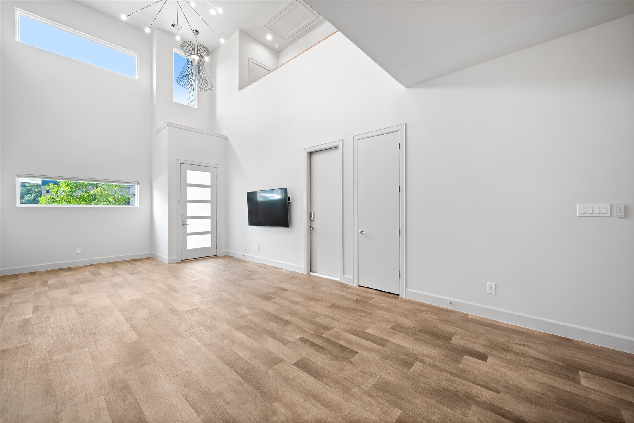 6809 Troya Lane Houston, TX 77092 - Photo 8 of 49 Soaring ceilings, designer light fixtures, and abundant natural light set the tone the moment you step inside. Sleek tile floors and architectural windows make this space feel open, bright, and effortlessly stylish.