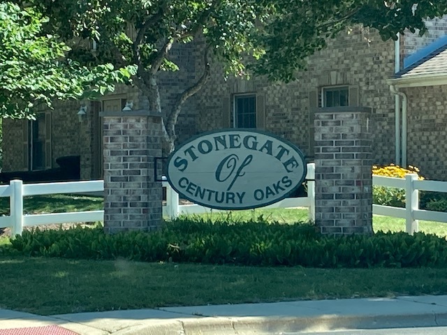 1945 Matthew Court, Unit D Elgin, IL 60123 - Photo 22 of 22 a sign that is sitting on a wooden bench in a yard