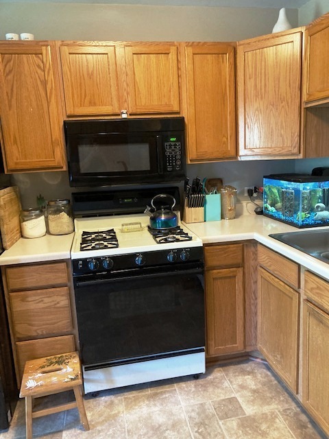 1945 Matthew Court, Unit D Elgin, IL 60123 - Photo 5 of 22 a kitchen with granite countertop a stove top oven microwave and cabinets