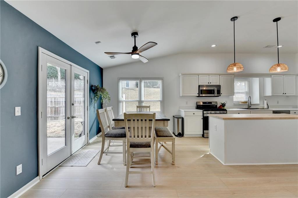 6435 Dressage Crossing Cumming, GA 30040 - Photo 11 of 35 a living room with stainless steel appliances kitchen island granite countertop furniture and a wooden floor