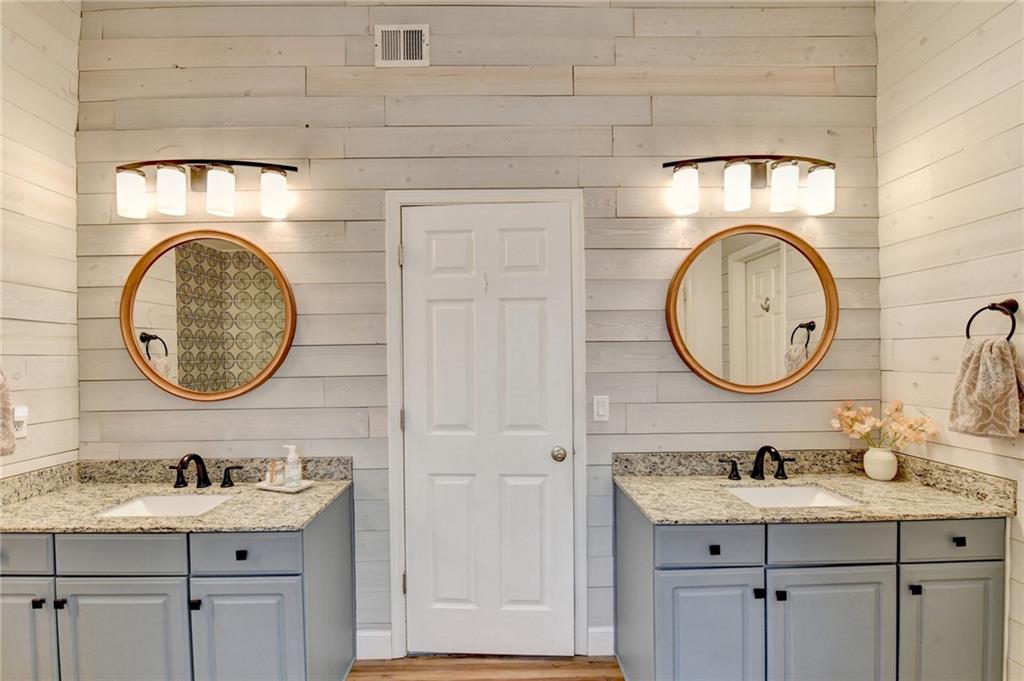 6435 Dressage Crossing Cumming, GA 30040 - Photo 19 of 35 a bathroom with a granite countertop toilet a sink and a mirror