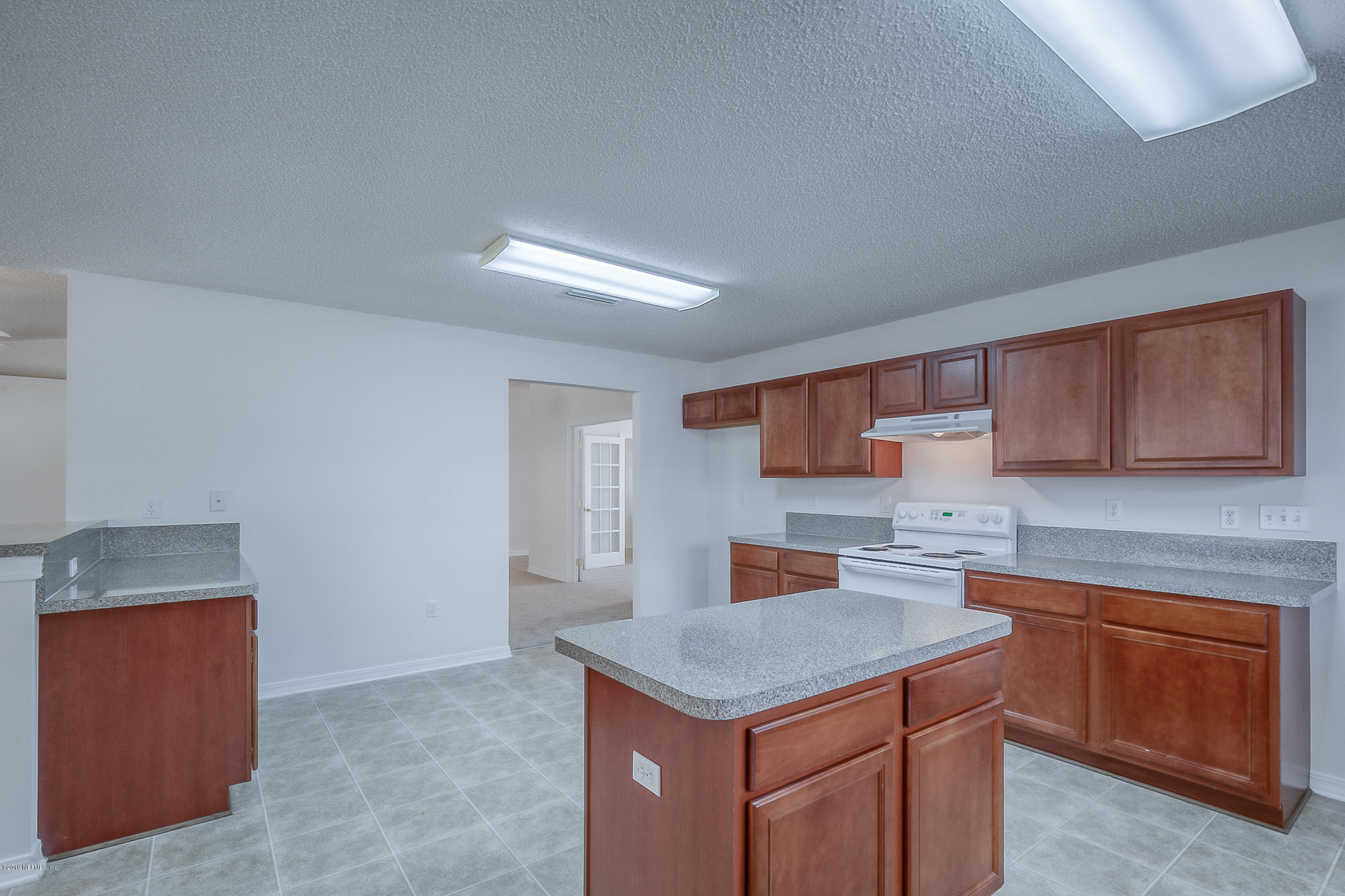 2633 Springwillow Drive Jacksonville, FL 32221 - Photo 16 of 33 a kitchen that has a sink a microwave oven a stove and white cabinets