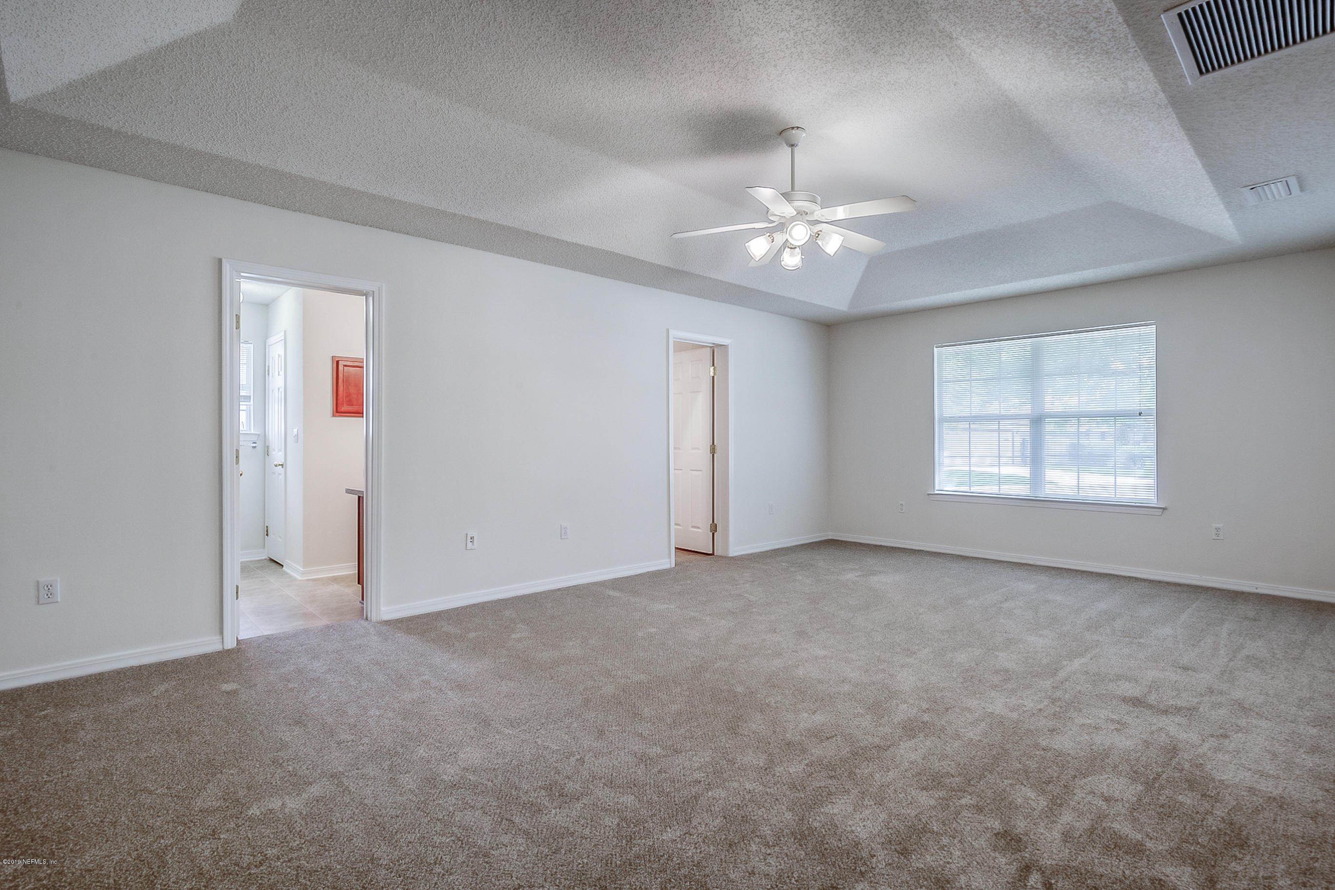 2633 Springwillow Drive Jacksonville, FL 32221 - Photo 20 of 33 an empty room with chandelier fan and windows