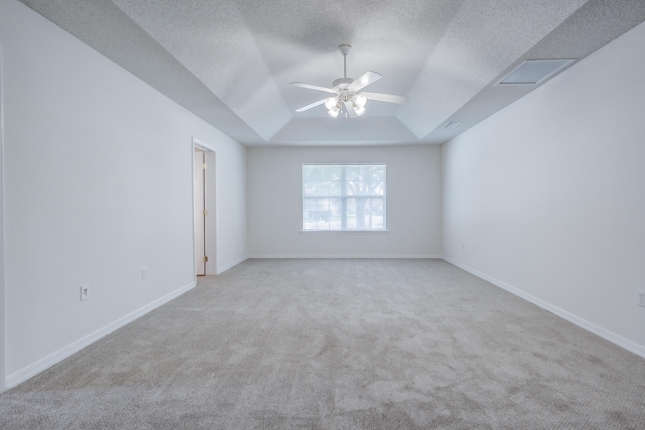 2633 Springwillow Drive Jacksonville, FL 32221 - Photo 21 of 33 an empty room with a chandelier fan and windows