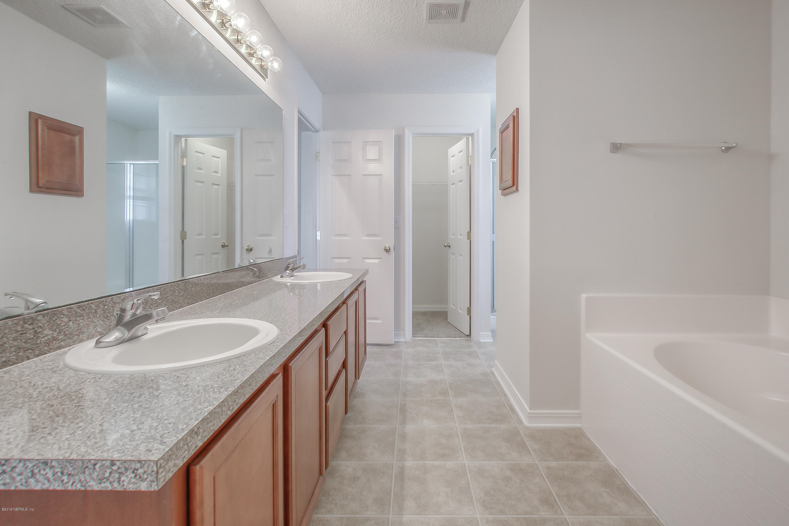 2633 Springwillow Drive Jacksonville, FL 32221 - Photo 23 of 33 a bathroom with a granite countertop sink a mirror and a bathtub