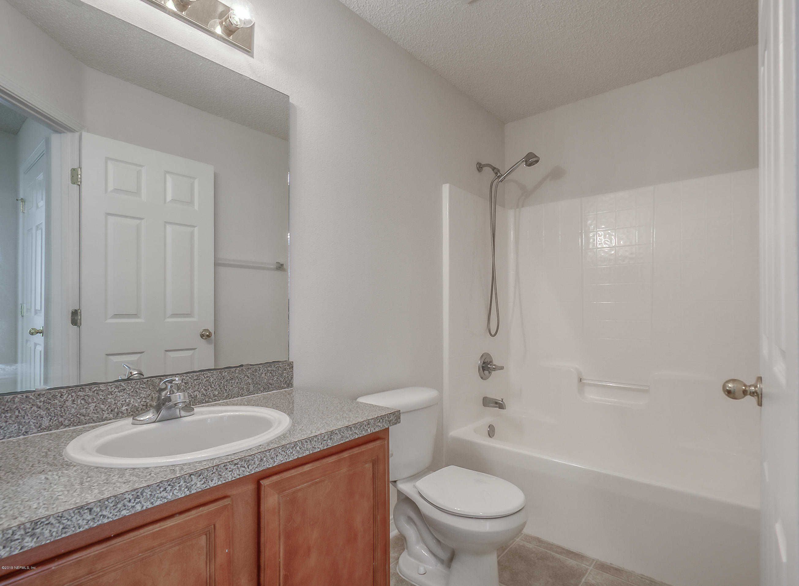 2633 Springwillow Drive Jacksonville, FL 32221 - Photo 28 of 33 a bathroom with a granite countertop sink a toilet and shower