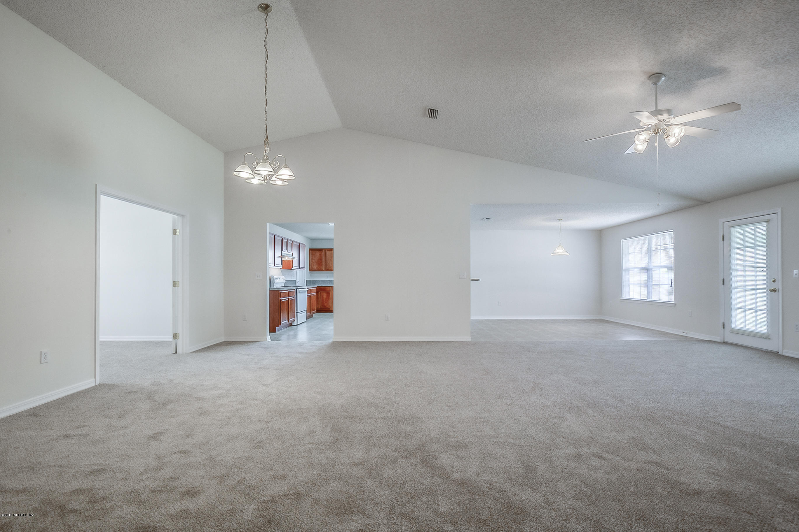 2633 Springwillow Drive Jacksonville, FL 32221 - Photo 7 of 33 an empty room with chandelier fan and windows