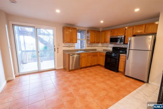 a kitchen with stainless steel appliances granite countertop a refrigerator a stove top oven and a refrigerator