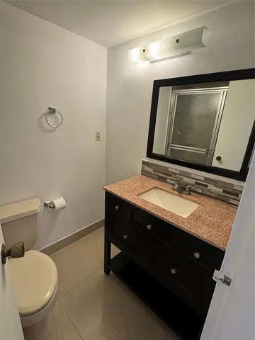 a bathroom with a sink a toilet and mirror