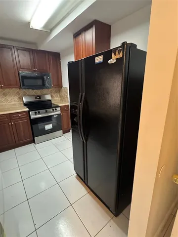 a kitchen with stainless steel appliances granite countertop a refrigerator and a stove top oven