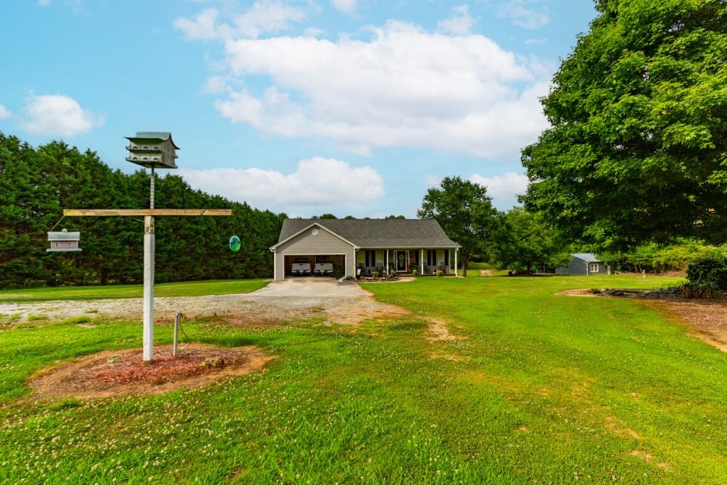 1042 Harbins Road Dacula, GA 30019 - Photo 33 of 33 a front view of a house with garden and trees