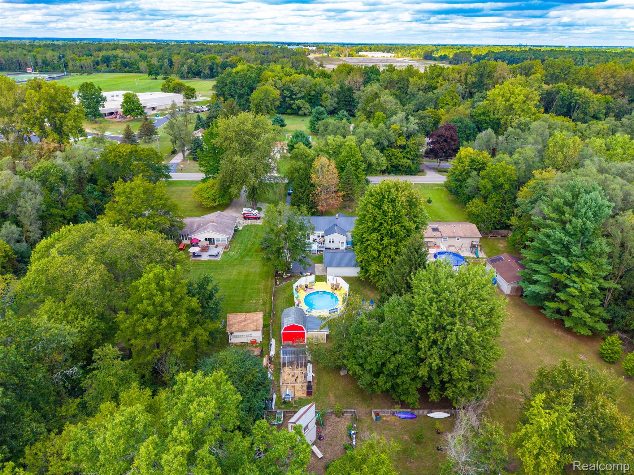 36739 Wick Road Romulus, MI 48174 - Photo 48 of 56 Aerial perspective showcasing multiple properties, lush green landscaping, and an above-ground swimming pool