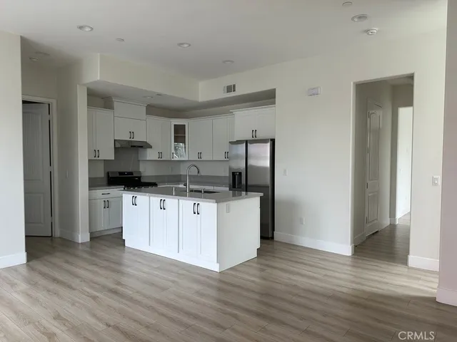 a kitchen with a refrigerator and a stove top oven
