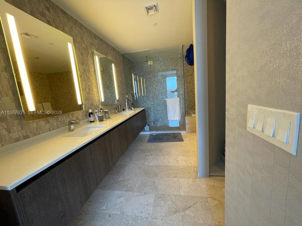 88 Southwest 7th Street, Unit 3609 Miami, FL 33130 - Photo 6 of 25 a bathroom with a double vanity sink and mirror