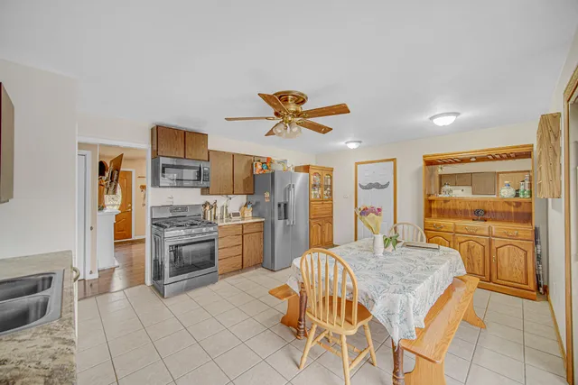 a kitchen with stainless steel appliances kitchen island granite countertop a refrigerator and microwave