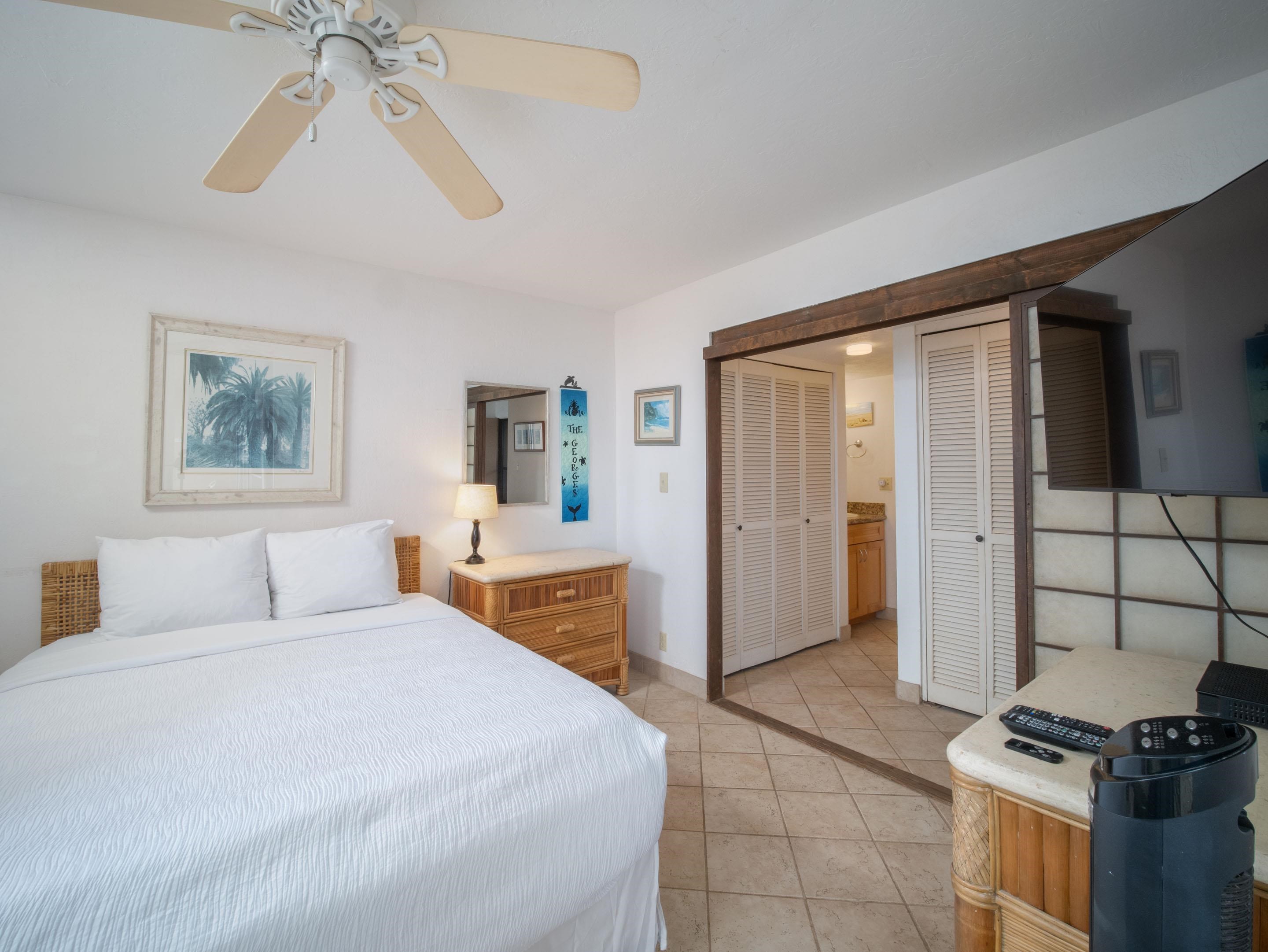 3723 Lower Honoapiilani Road, Unit 104 Lahaina, HI 96761 - Photo 11 of 45 a bedroom with a bed and a chandelier