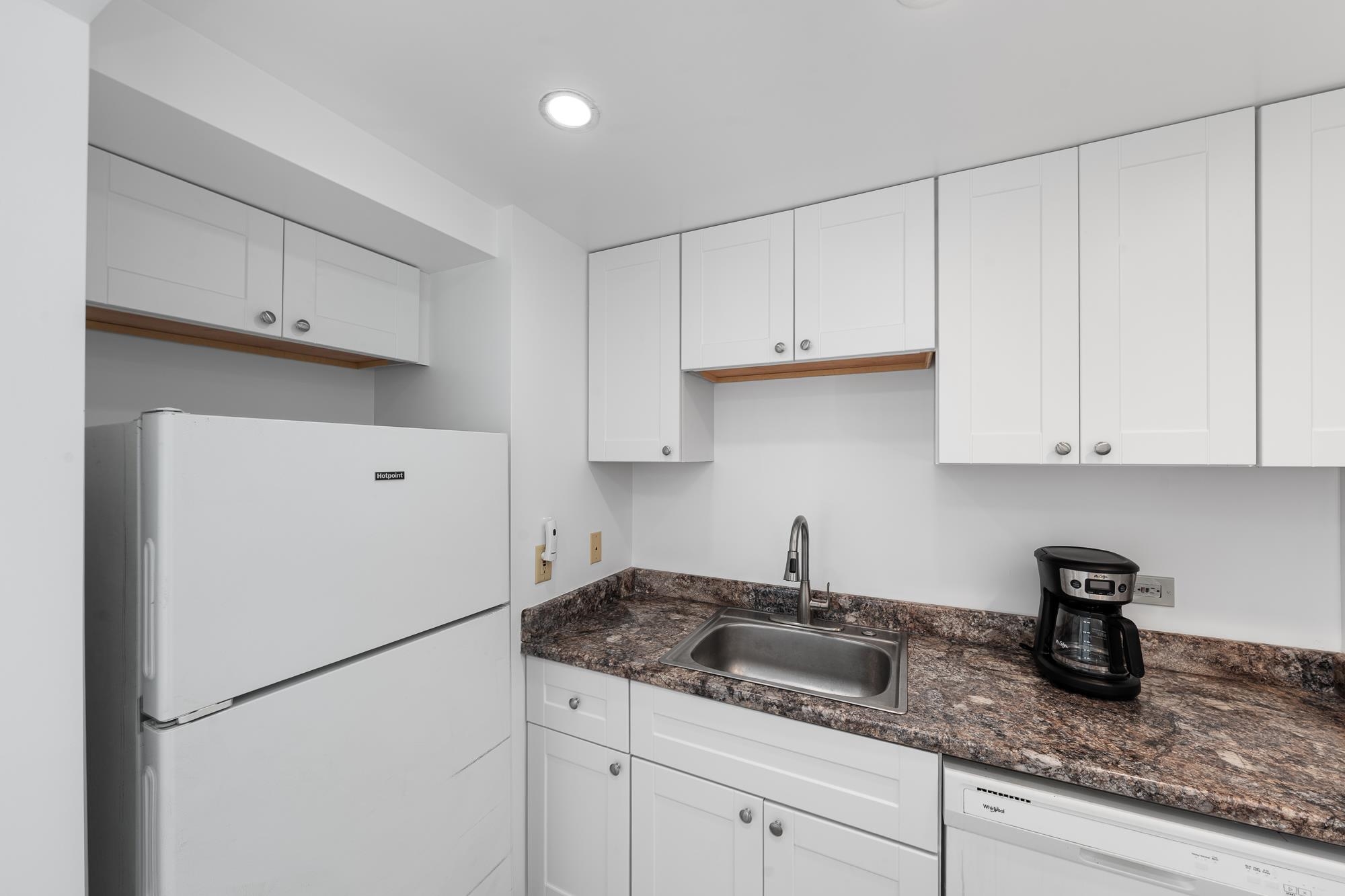 3723 Lower Honoapiilani Road, Unit 104 Lahaina, HI 96761 - Photo 8 of 45 a kitchen with granite countertop white cabinets and white appliances