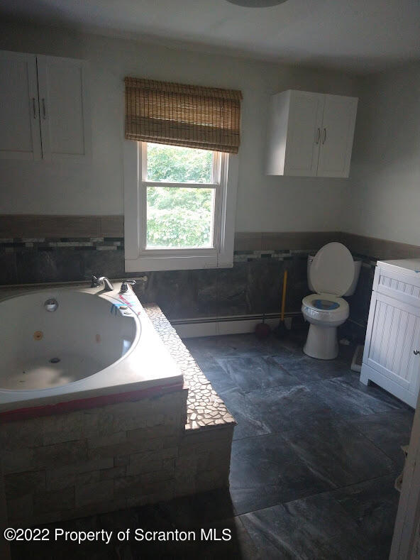 106 T Rte 718 Moscow, PA 18444 - Photo 8 of 15 a bath tub sitting in a bathroom next to a window