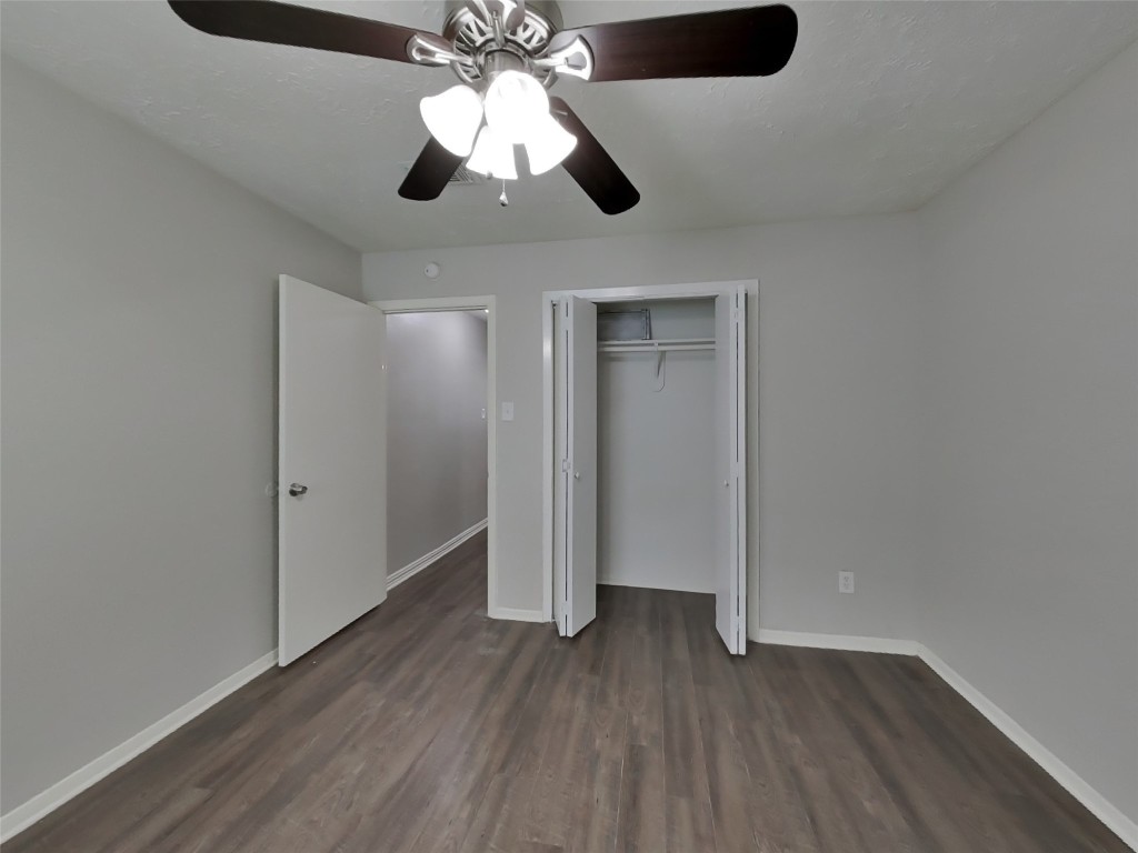 4227 Burkegate Drive Spring, TX 77373 - Photo 11 of 15 an empty room with wooden floor chandelier fan and closet area