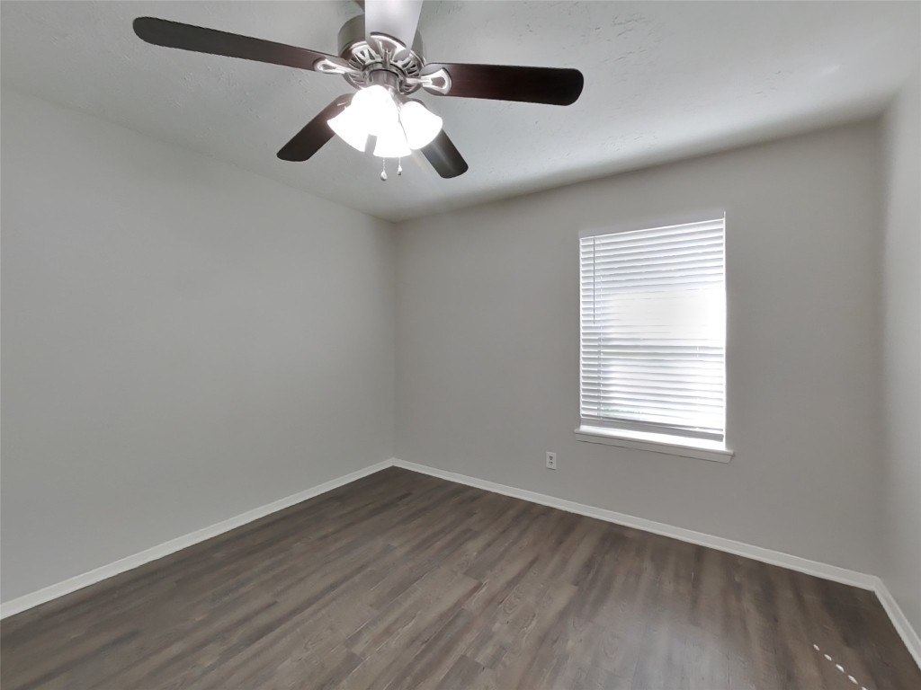 4227 Burkegate Drive Spring, TX 77373 - Photo 12 of 15 an empty room with wooden floor ceiling fan and windows