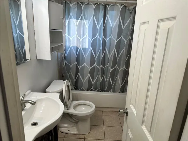a white toilet sitting next to a shower curtain