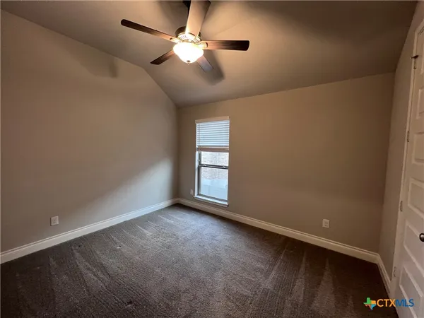 en empty room with windows and ceiling fan