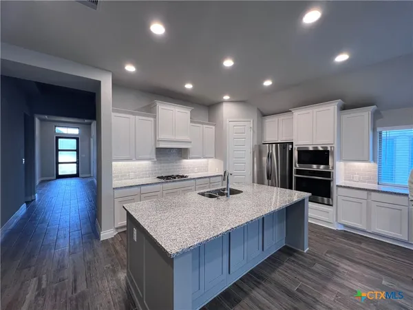 a kitchen with stainless steel appliances granite countertop a stove and refrigerator