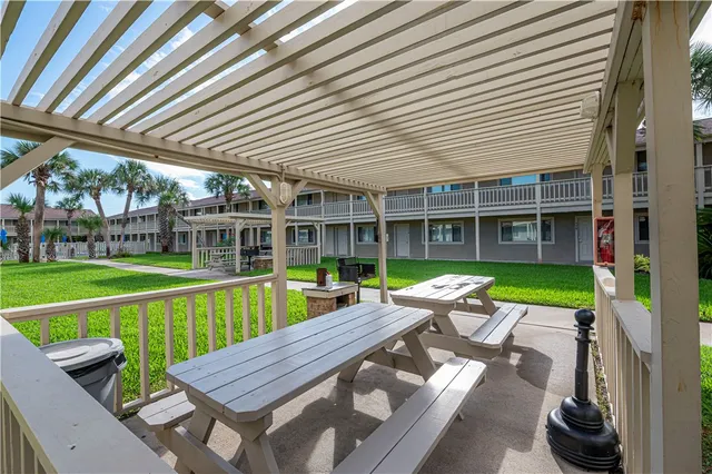 a view of a patio with table and chairs next to a yard