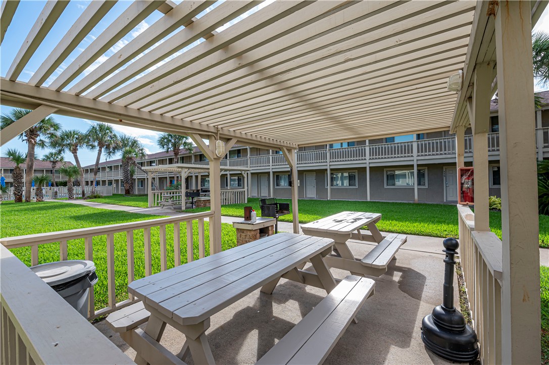 622 Beach Access Road Port Aransas, TX 78373 - Photo 16 of 19 a view of a patio with table and chairs next to a yard