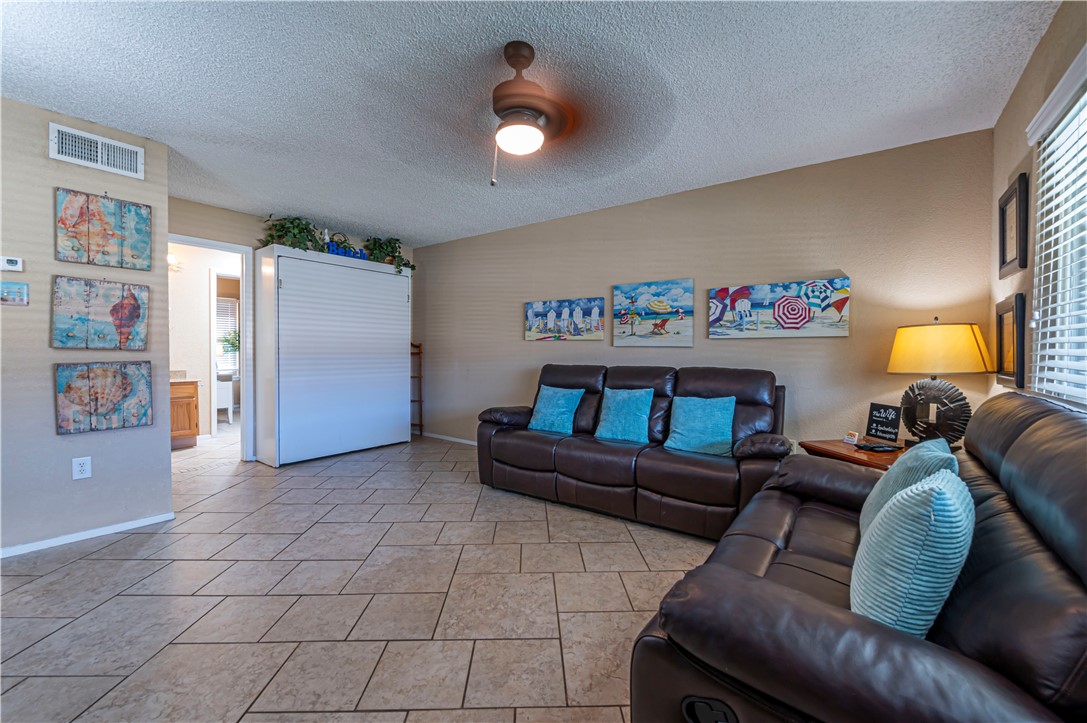622 Beach Access Road Port Aransas, TX 78373 - Photo 3 of 19 a living room with furniture and a lamp