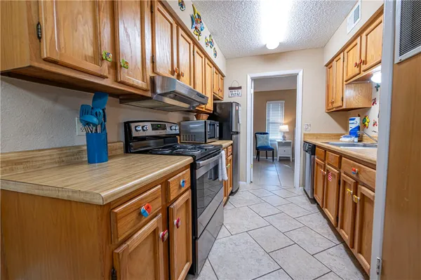 a kitchen with stainless steel appliances granite countertop a stove and a refrigerator