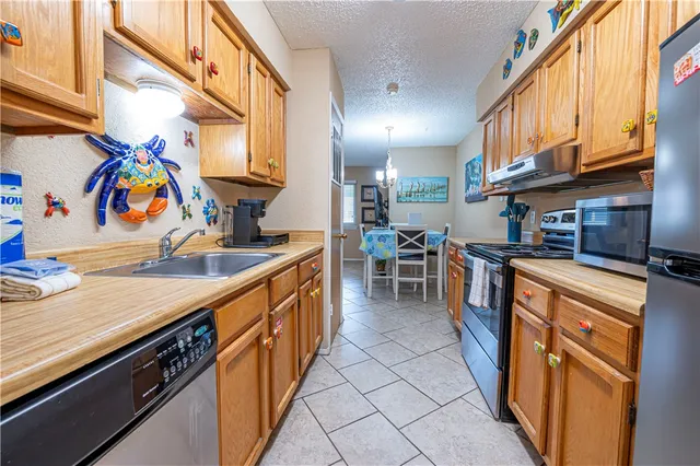 a kitchen with stainless steel appliances granite countertop a sink and a refrigerator