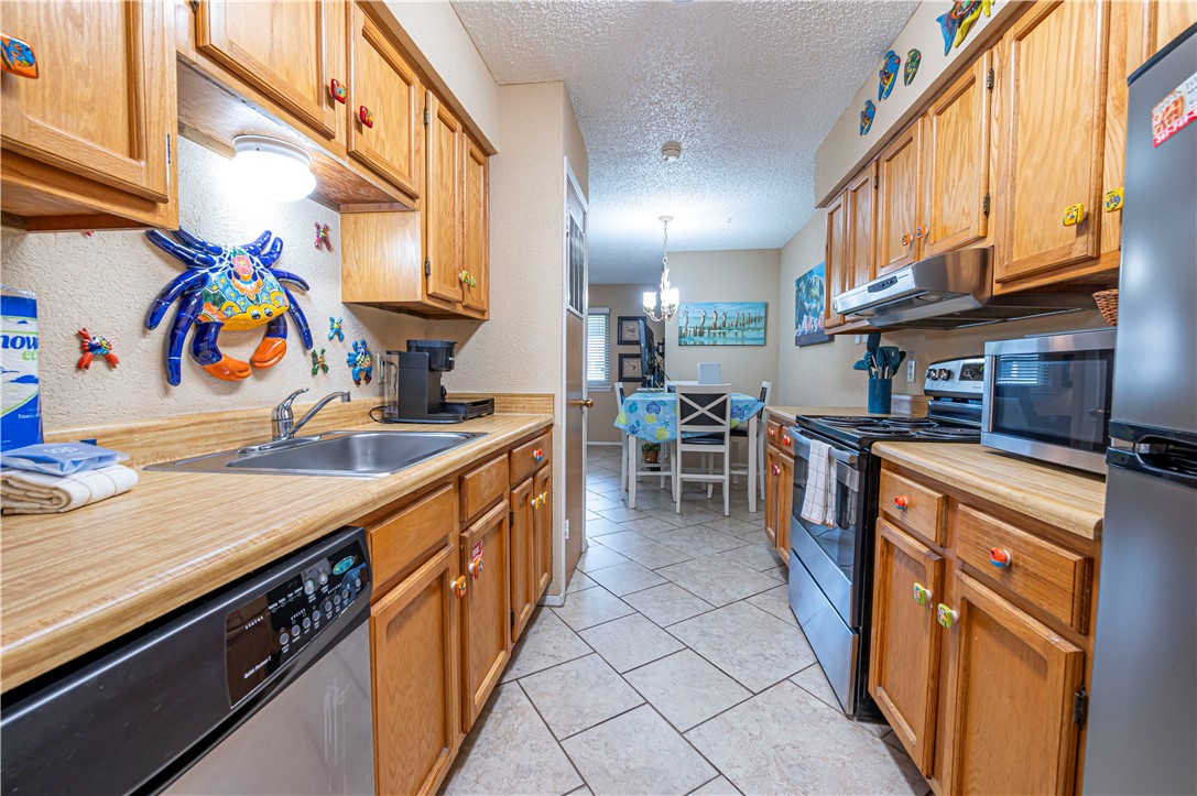 622 Beach Access Road Port Aransas, TX 78373 - Photo 7 of 19 a kitchen with stainless steel appliances granite countertop a sink and a refrigerator