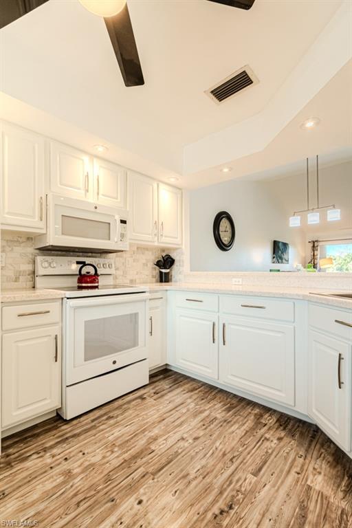 1850 West Crown Pointe Boulevard, Unit A202 Naples, FL 34112 - Photo 16 of 44 a kitchen with white cabinets and white appliances