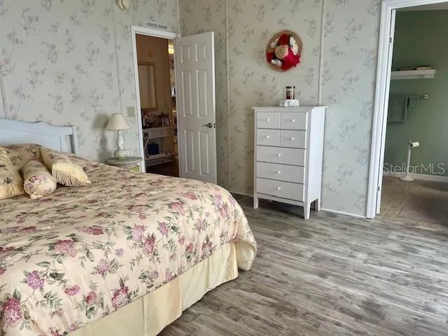 a view of a hallway with wooden floor and cabinet