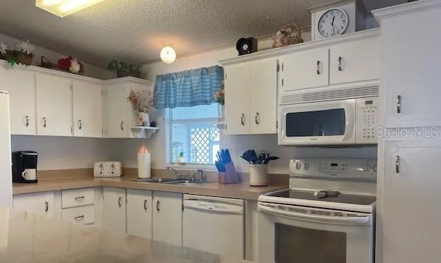 a kitchen with cabinets stainless steel appliances and a sink