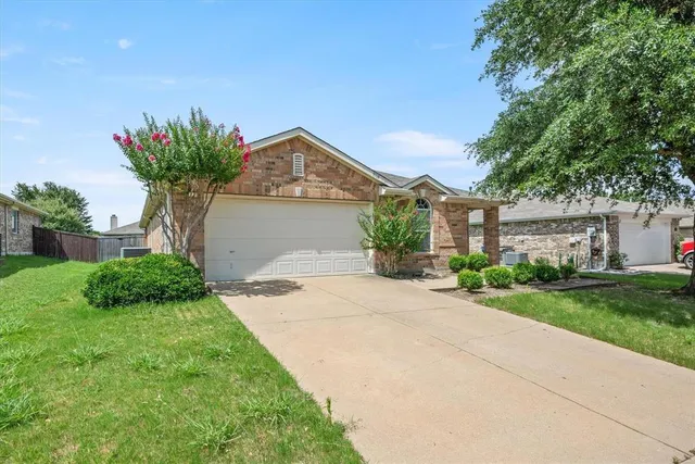 a front view of a house with a garden and trees