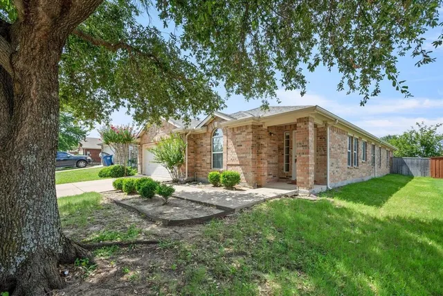 a view of a house with backyard and a tree