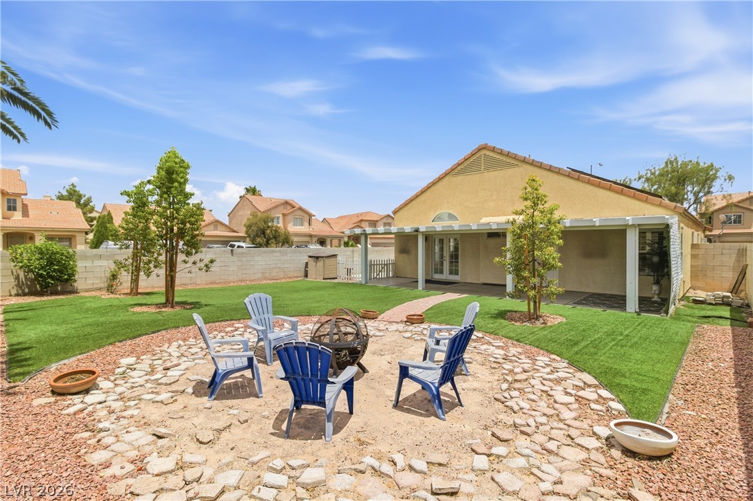 9523 Observer Street Las Vegas, NV 89123 - Photo 38 of 42 A spacious backyard with a fire pit, covered patio, and lush artificial turf creates an ideal outdoor retreat.
